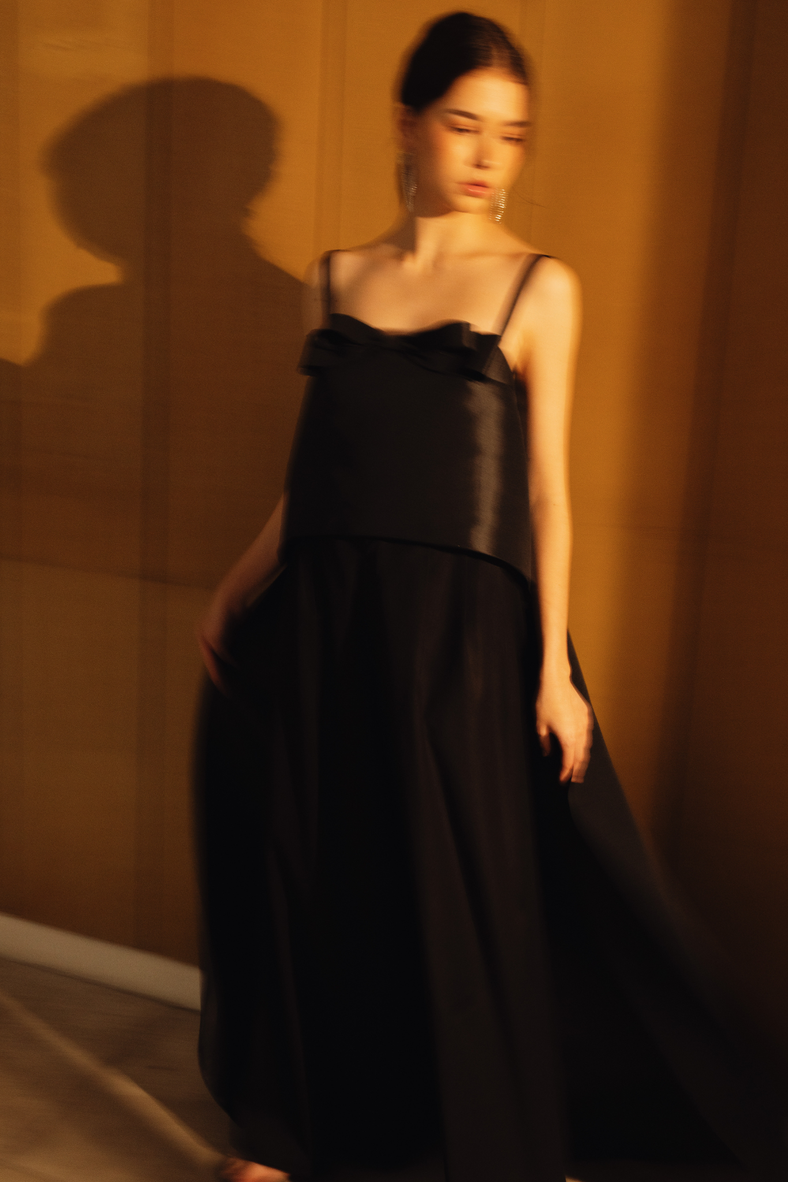 Vania Romoff The Nancy Top in black is crafted in crisp taffeta and features a high–low hem