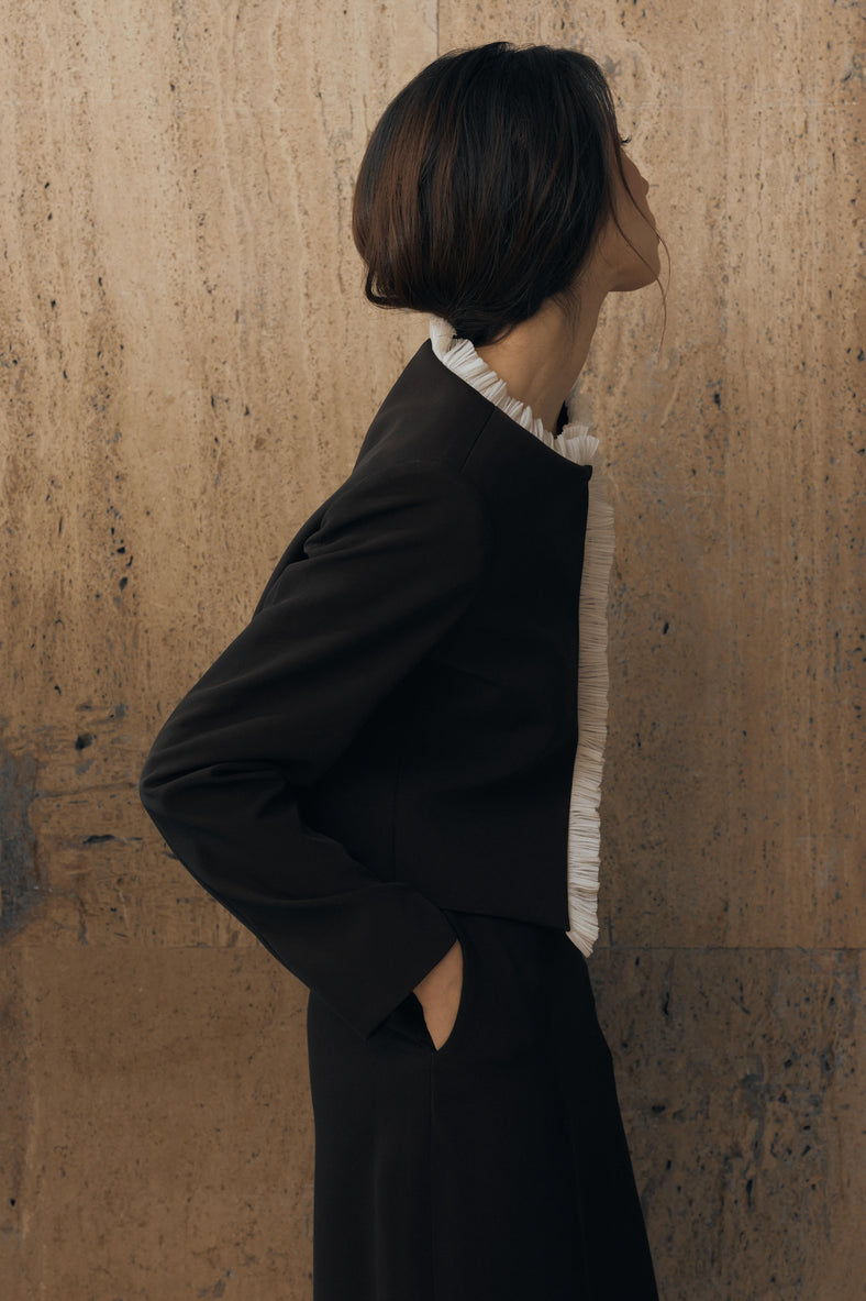 Vania Romoff The Ada Jacket in black and white features a structured silhouette in black neocrepe. Contrasting white trim frames the neckline 