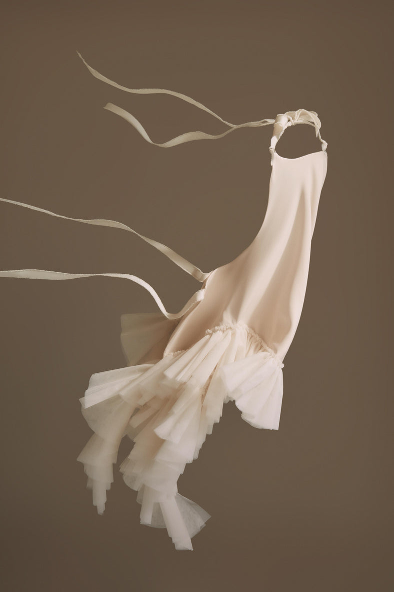  Vania Romoff The Clara Top in ivory features a halter neckline and a relaxed, flowing silhouette in ivory stretch crepe