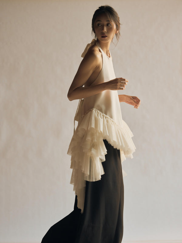  Vania Romoff The Clara Top in ivory features a halter neckline and a relaxed, flowing silhouette in ivory stretch crepe