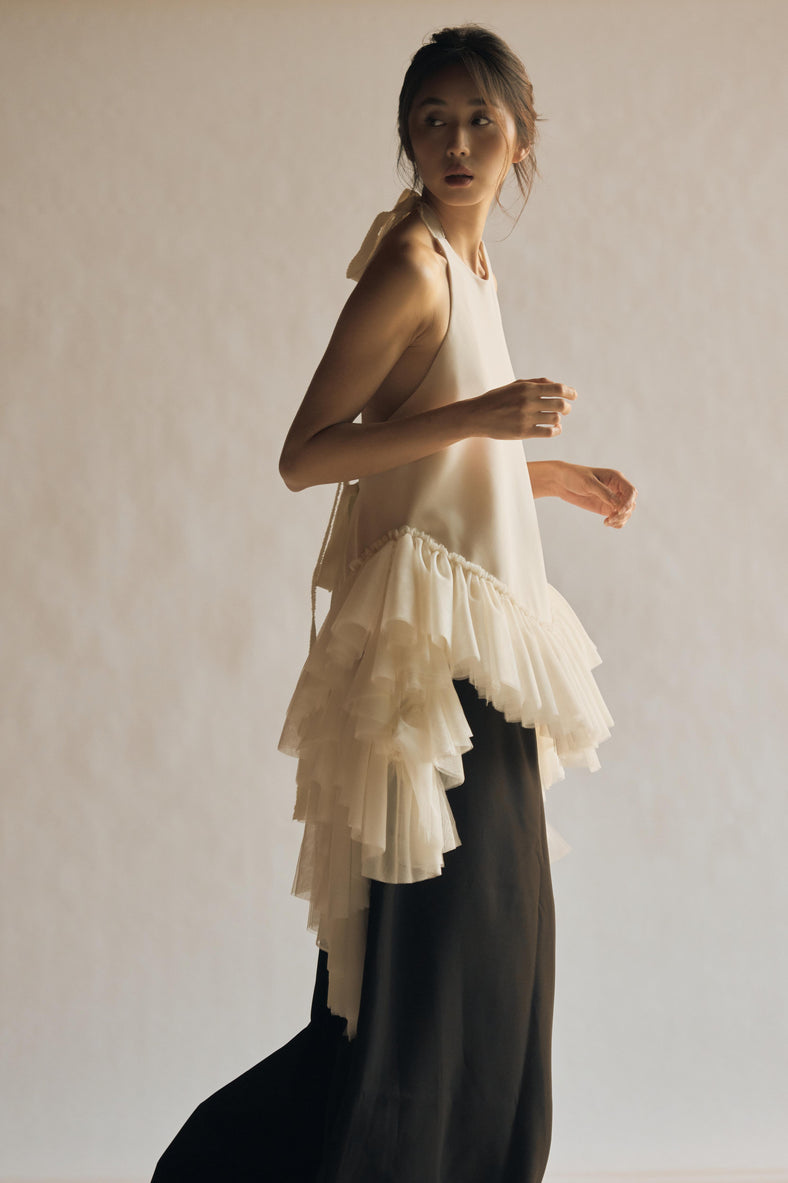  Vania Romoff The Clara Top in ivory features a halter neckline and a relaxed, flowing silhouette in ivory stretch crepe