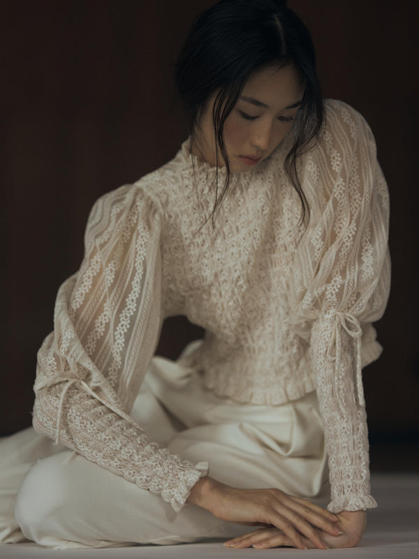 Vania Romoff The Juliet Top in oat is crafted from delicate lace and features intricate ruching, a high neckline, and sheer sleeves