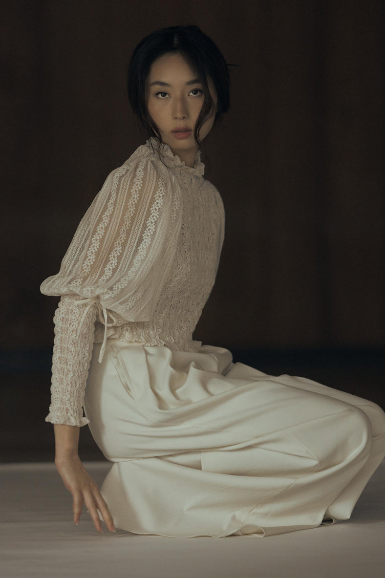 Vania Romoff The Juliet Top in oat is crafted from delicate lace and features intricate ruching, a high neckline, and sheer sleeves