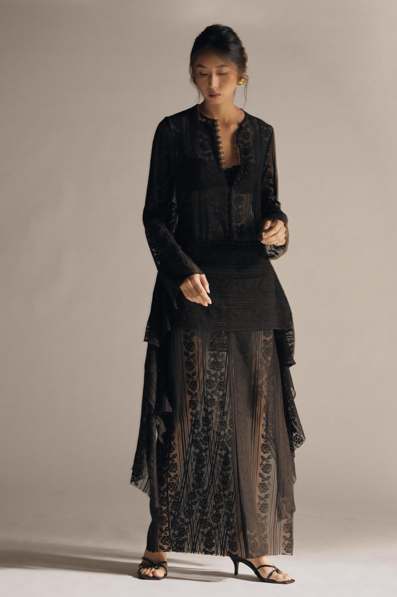 Vania Romoff The Ruth Dress in black  features delicate black floral lace, a plunging neckline, and long sleeves