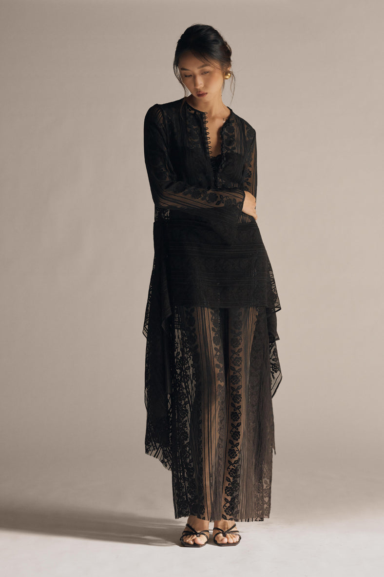 Vania Romoff The Ruth Dress in black  features delicate black floral lace, a plunging neckline, and long sleeves