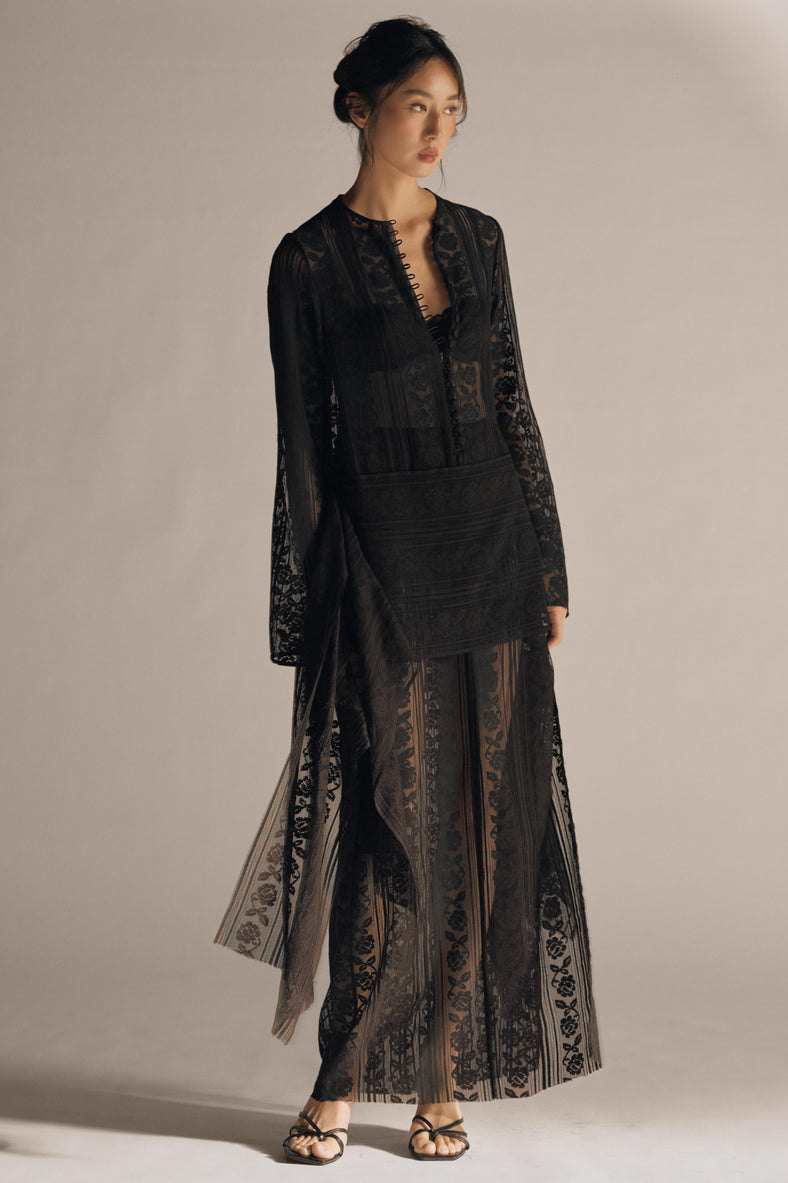 Vania Romoff The Ruth Dress in black  features delicate black floral lace, a plunging neckline, and long sleeves